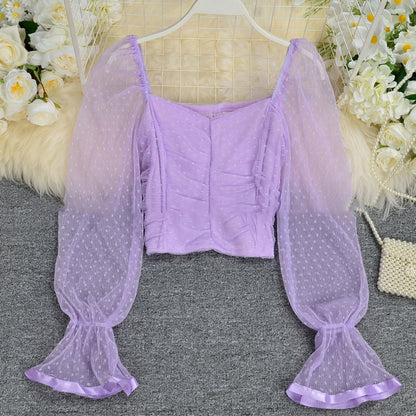 Elegant white flared sleeve crop top with sheer mesh detailing, perfect for stylish and trendy women's fashion outfits in the UAE.