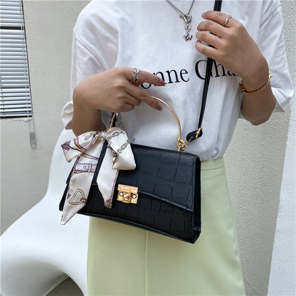 Stylish black textured crossbody handbag with decorative silk scarf accessory, perfect for modern daily and fashion-forward looks in the UAE.