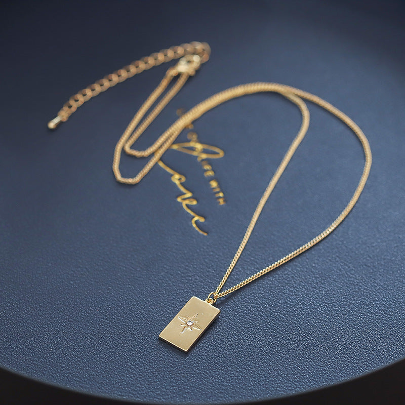Close-up of an elegant gold floral-shaped geometric necklace with sparkling crystals, displayed on a dark surface for a luxury fashion look.