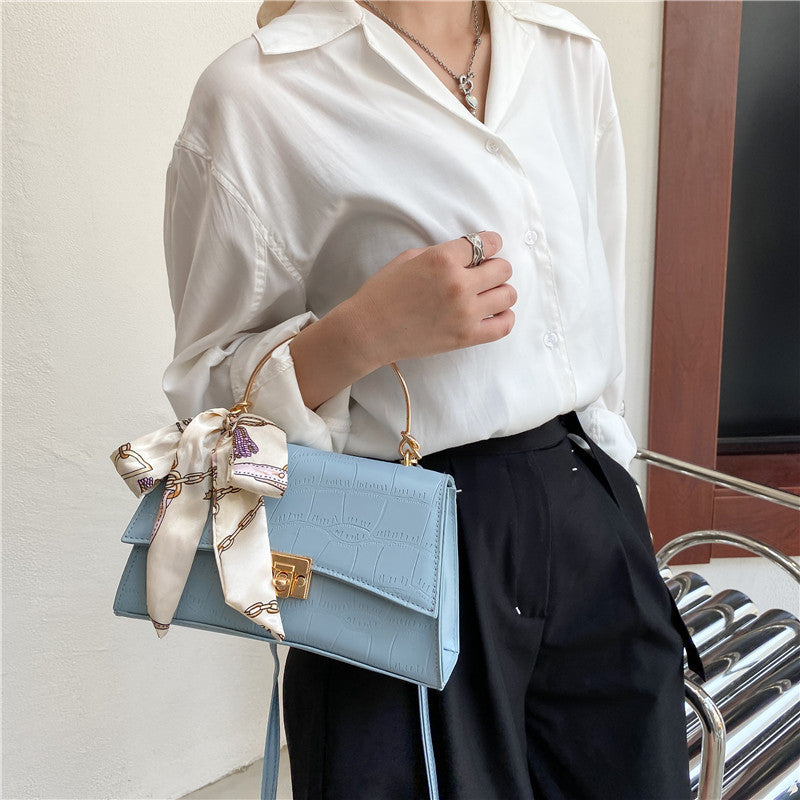 Stylish black textured crossbody handbag with decorative silk scarf accessory, perfect for modern daily and fashion-forward looks in the UAE.