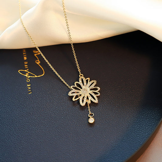 Close-up of an elegant gold floral-shaped geometric necklace with sparkling crystals, displayed on a dark surface for a luxury fashion look.